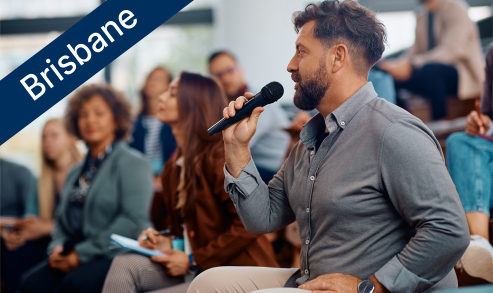 Man speaking into microphone at an event